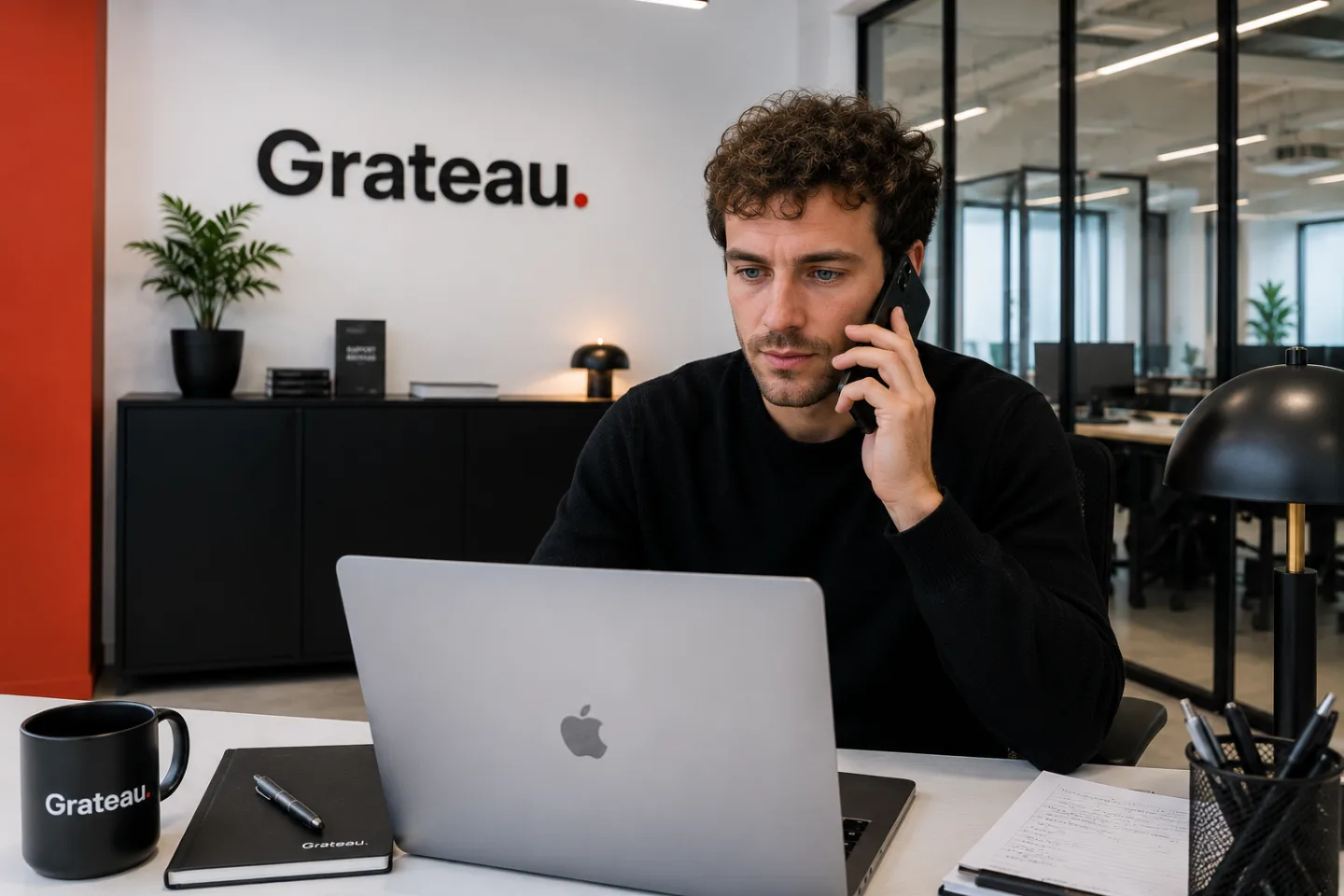 Un chef de projet Grateau Agency au téléphone avec un client, dans les bureaux de l'agence